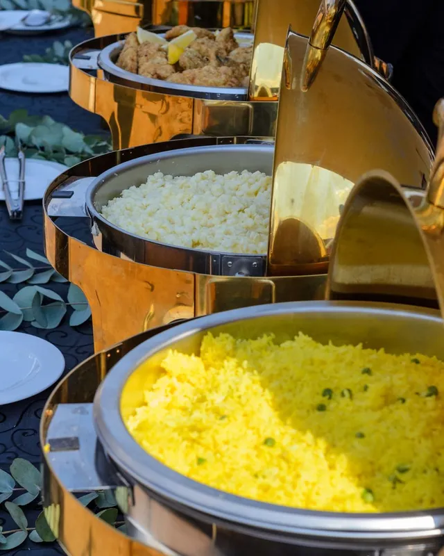 Nasi kuning dan lauk dalam wadah saji berwarna emas