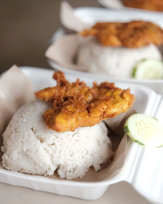 Nasi putih dengan ayam goreng dan timun dalam kotak makan
