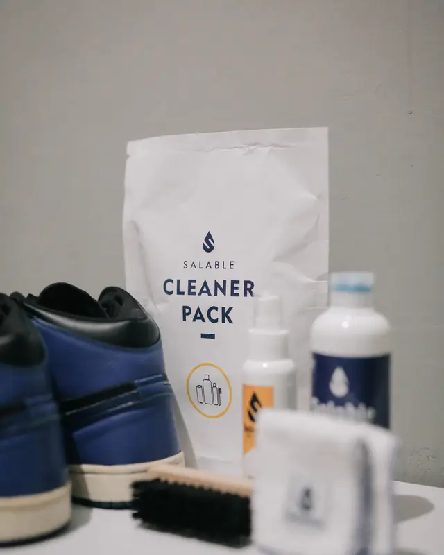 Sepatu sneakers di samping perlengkapan cuci sepatu