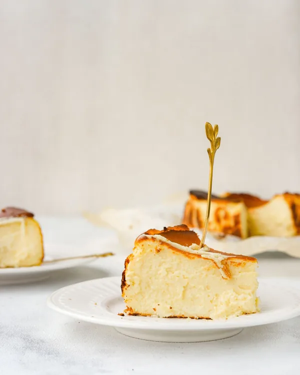 Slice of burnt Basque cheesecake on a white plate