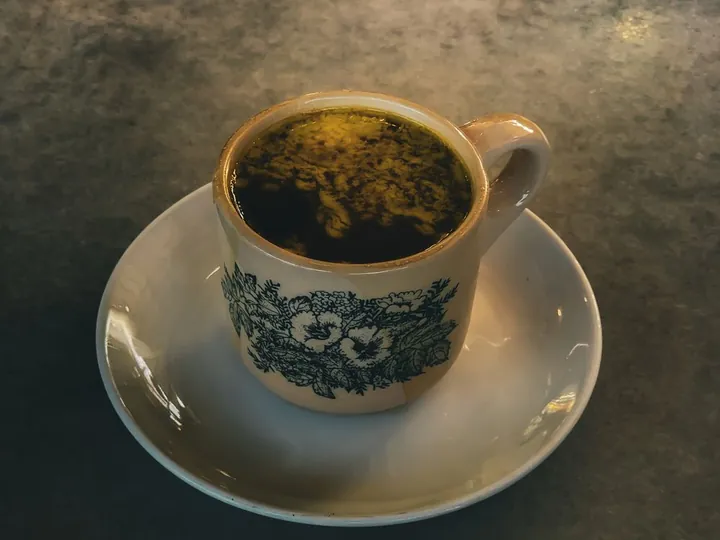 Black coffee in a vintage cup on a marble table