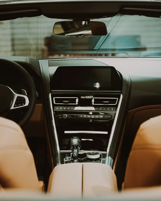 Clean car interior with tan leather seats and a wiped-down center console
