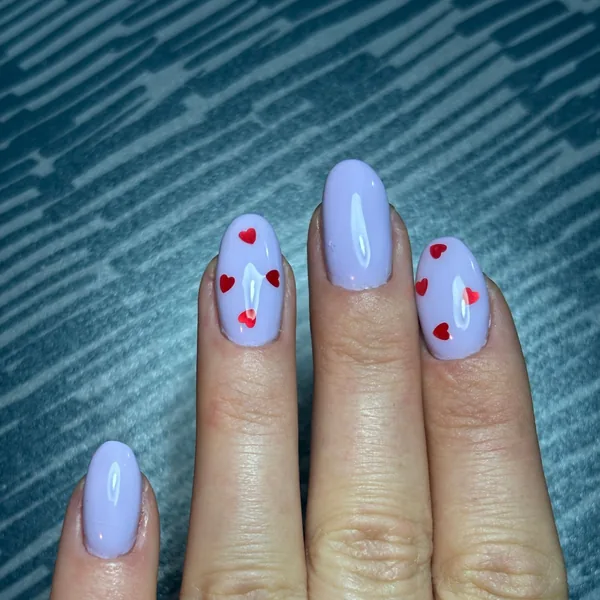 Lavender gel nails with small red hearts on two fingers